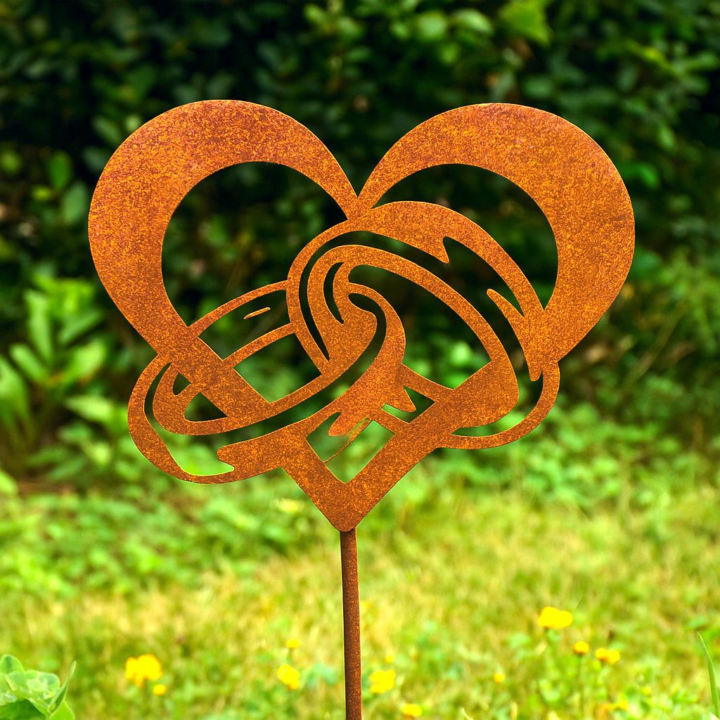 Herz mit Ringen aus Edelrost auf Erdspieß – romantische Gartendeko als Symbol für Liebe und Verbundenheit.