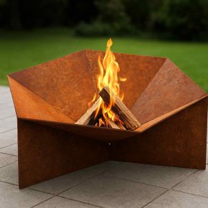 Sechseckige Feuerschale V7 aus Edelrost Stahl mit brennendem Feuer im Garten – handgefertigte Feuerstelle aus massivem Stahl