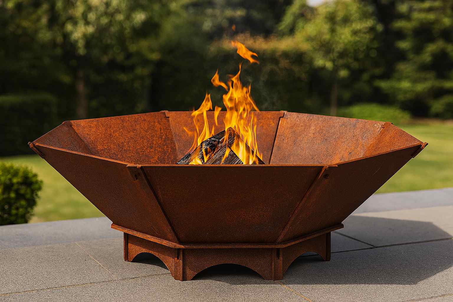 Große achteckige Feuerschale aus Edelrost Stahl mit brennendem Feuer im Garten – massive handgefertigte Feuerstelle aus 5 mm Stahl